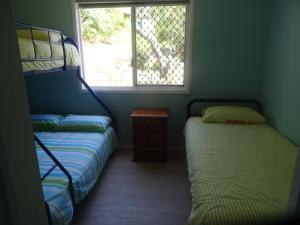 a bedroom with two bunk beds and a window at Elouera Units in Fraser Island