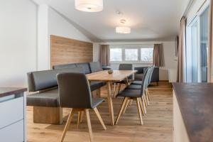 a kitchen and dining room with a wooden table and chairs at Panorama Lodge Premium Apartments in Schladming