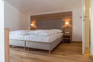 a bedroom with a large bed with white sheets at Panorama Lodge Premium Apartments in Schladming