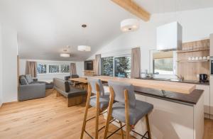 cocina y sala de estar con mesa y sillas en Panorama Lodge Premium Apartments en Schladming