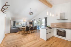 a kitchen and dining room with a table and chairs at Panorama Lodge Premium Apartments in Schladming +37 photos