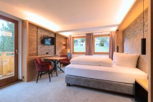 Habitación de hotel con cama y mesa en Hotel Garni Feuerstein, en Sankt Anton am Arlberg