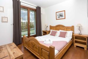 a bedroom with a large wooden bed and a window at Pothecary apartment -Chamonix All Year in Chamonix-Mont-Blanc