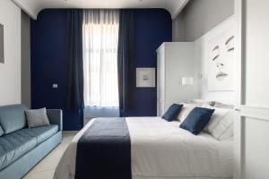 - une chambre bleue avec un grand lit et un canapé dans l'établissement My Lodge Italy Centro Storico, à Naples
