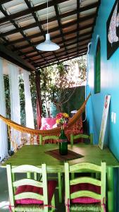 a hammock on a porch with a table and chairs at Chale Kangaroos Imbassai in Imbassai