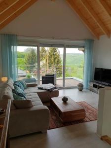 a living room with a couch and a large window at Ferienhaus May in Utzenhain