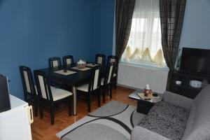 a living room with a table and chairs and a couch at Blue House Apartment in Niš
