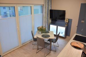 a dining room with a table and chairs and a television at Ostsee-Kay in Graal-Müritz