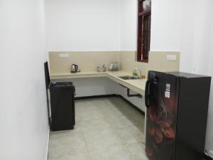 a small kitchen with a sink and a refrigerator at Mangroven River View Hotel in Bentota