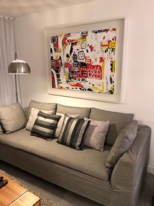 un sofá en una sala de estar con una pintura en la pared en Yoo Punta del Este, en Punta del Este