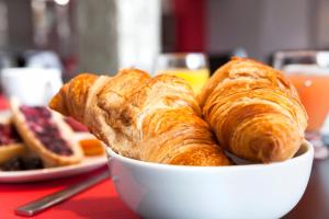 a bowl of croissants and bread on a table at Hôtel Le Nautic in Arcachon