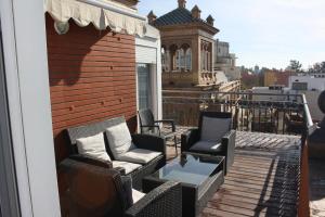 a patio with chairs and a table on a balcony at Apartamentos Avenida in Seville