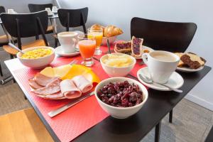 a table with breakfast foods and drinks on it at Hôtel Le Nautic in Arcachon