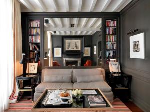 a living room with a couch and a table at MARQUIS Faubourg Saint-Honoré Relais & Châteaux in Paris