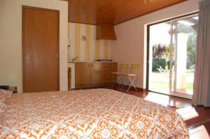 a bedroom with a large bed and a large window at Apartamentos Vale Da Varzea in Areia Branca