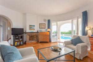 a living room with a couch and a table at Villa Caprice in S'Algar