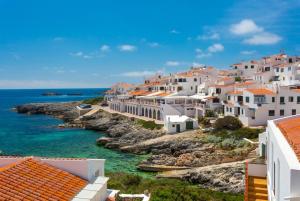 a group of white houses on a rocky island in the ocean at Villa Caprice in S'Algar