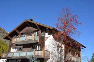 ein Apartmenthaus mit einem Baum davor in der Unterkunft Haus Alpenperle in Saas-Almagell