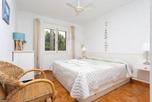 a bedroom with a bed and a chair and a window at Villa Caprice in S'Algar +37 photos