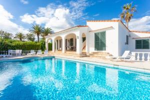 a villa with a swimming pool and a house at Villa Caprice in S'Algar