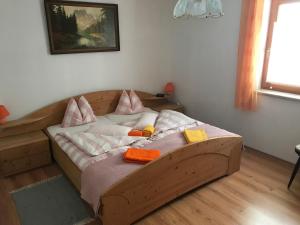 ein Holzbett mit Kissen darauf in einem Zimmer in der Unterkunft Ferienhaus Dorfblick in Außervillgraten