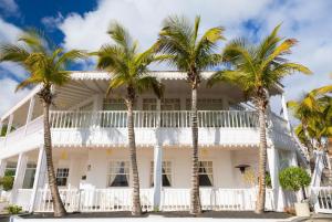 a white house with palm trees in front of it at Villa Gaida in Puerto Calero