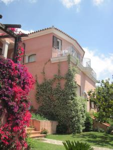 een roze huis met bloemen ervoor bij Bed & Breakfast Dessole in Olbia