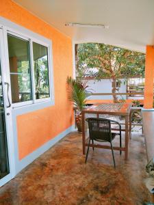 an orange room with a table and a chair at Baan Chid Talay in Ko Chang