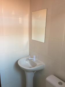 uma casa de banho com um lavatório, um espelho e um WC. em Flat Thermas Olimpia - 300 metros do Thermas dos Laranjais em Olímpia