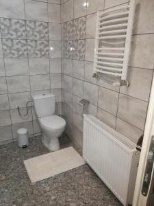 a bathroom with a white toilet and a radiator at Pokój gościnny ROYAL in Świeradów-Zdrój