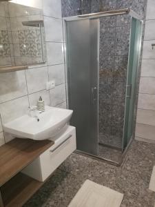 a bathroom with a white sink and a shower at Pokój gościnny ROYAL in Świeradów-Zdrój