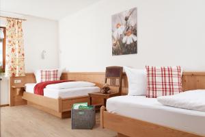 a bedroom with two beds and a painting on the wall at Gästehaus Hornblick in Oberstdorf