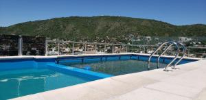 Una piscina en la parte superior de un edificio con una montaña. en Torre del Lago I, en Villa Carlos Paz