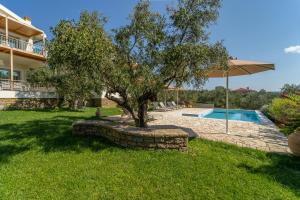 una casa con un árbol y una piscina en Abelia Luxurious Villas, en Finikounta