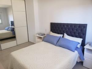 Un dormitorio con una cama grande y un espejo. en Torre del Lago I, en Villa Carlos Paz 14 fotos más