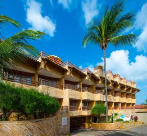 un hotel con una palmera delante en Pipa's Bay Flats, en Pipa