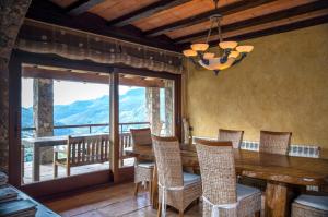 a dining room with a table and chairs and a balcony at Serrat del Vent - Adults only in Ribes de Freser
