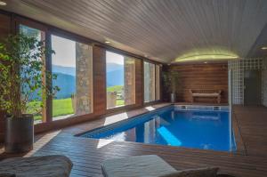 a swimming pool in a house with a large window at Serrat del Vent - Adults only in Ribes de Freser