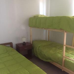 伊基克的住宿－Amunátegui 2090 Iquique，一间卧室设有两张双层床和床头柜。