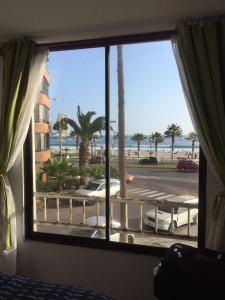 een slaapkamer met een raam met uitzicht op het strand bij Amunátegui 2090 Iquique in Iquique