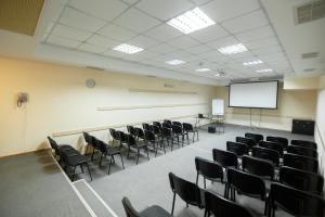 a conference room with chairs and a white screen at Optima Kropivnytskiy Hotel in Kropyvnytskyi