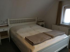 a bedroom with a white bed with two pillows on it at Schaalseeblick in Zarrentin