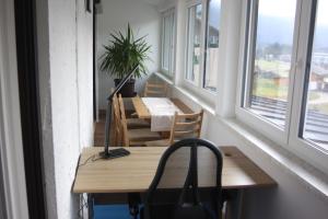 Habitación con mesa, sillas y ventanas. en Ferienwohnung Haus Cerny en Bad Goisern