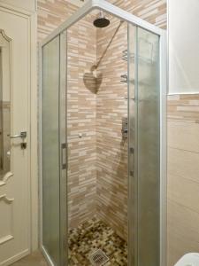 una doccia con una porta in vetro in un bagno di La Casa Sotto I Tigli a Lecco Altre 43 foto