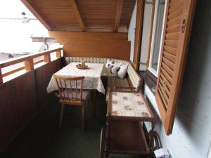 イムストにあるFerienhaus Tschenettのテーブルと椅子、窓が備わる小さな客室です。