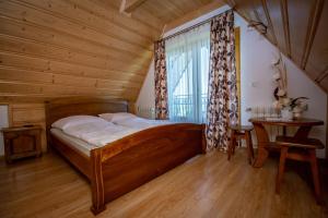 1 dormitorio con cama de madera y ventana en Podhalanski Dworek SPA, en Białka Tatrzanska