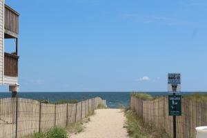a beach path with a fence and the ocean at Express INN in Norfolk