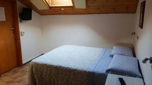 - une chambre avec un lit doté d'une couette bleue et d'une fenêtre dans l'établissement Foresteria Lombarda da Giovanna, à Barzio
