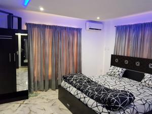 a bedroom with a bed and a large window at CG Apartments Metro in Ikeja