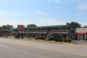 a store on a street with cars parked in front of it at Express INN in Norfolk